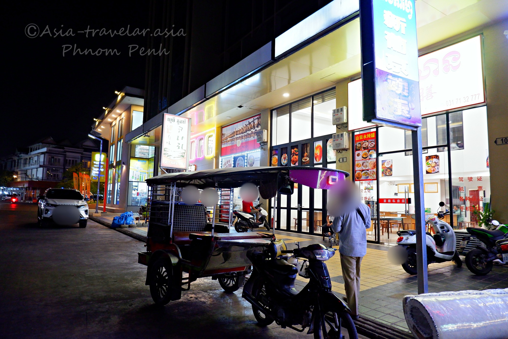 プノンペン夜の街に停まるトゥクトゥクと中華レストラン外観